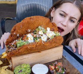 Guest eating the Schnitztaco filled with crumbed schnitzel and slaw