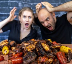 Guests reacting to the BBQ Meat Sack spread of ribs, sausages and corn