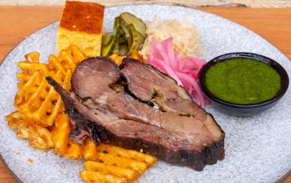 Sliced brisket with cornbread, waffle fries and chimichurri