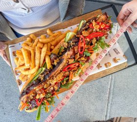 Monster BBQ Banh Mi measured with a tape measure, served with fries
