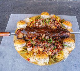 Excalibur Ribs Platter with a knife planted in the ribs, surrounded by garnishes