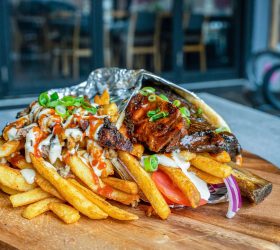 Ribovlaki rib wrap unwrapped in foil beside loaded fries