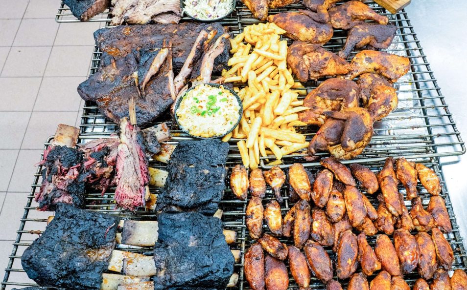 Racks of smoked meats and chicken prepped in the kitchen