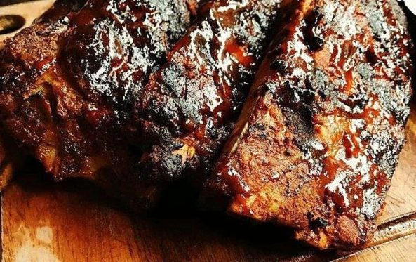 Glazed pork ribs sliced on a wooden board
