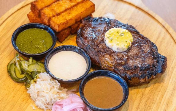 Grilled porterhouse steak with herb butter, sauces and sweet potato chips