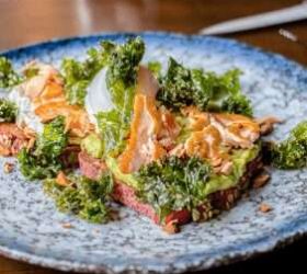 Open sandwich with smoked meat and crispy kale on a plate