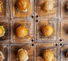 Mini burgers displayed in a wall of wooden cubby boxes