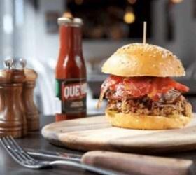 Pulled pork slider on a board beside a hot sauce bottle