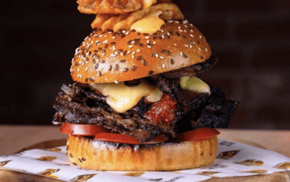 Ribsy burger stacked with smoked meat and a waffle fry skewer