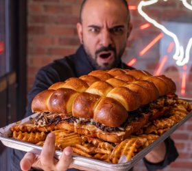 Person holding a giant slider slab tray with waffle fries