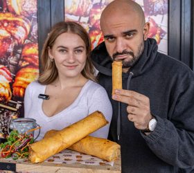 Guests holding XXXL Spring Rolls with dipping sauce and salad