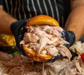 Pulled pork sandwich from the Whole Hog Degustation, hands pulling it apart