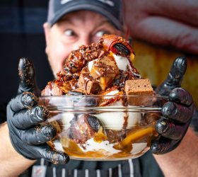 Guest giving a thumbs up holding the BBQ Bacon Sundae bowl