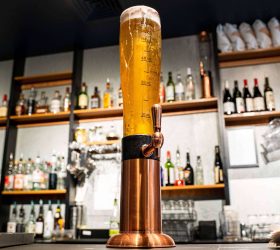 Copper drink tower on the bar with spirit bottles behind
