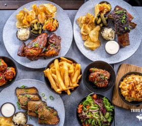 Overhead spread of sliders, fries, salad and mac and cheese sides