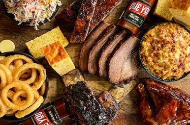 Overhead spread of brisket, ribs, onion rings and cornbread