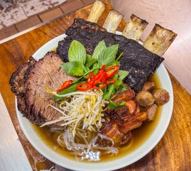 Holy Pho'ck broth bowl with a smoked rib rack and noodles