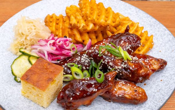 Glazed chicken wings with waffle fries and cornbread