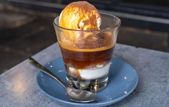 Affogato with a scoop of ice cream in espresso, served on a blue saucer