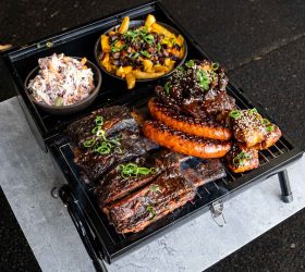 BBQ in a BBQ platter with ribs, sausage, brisket and loaded fries