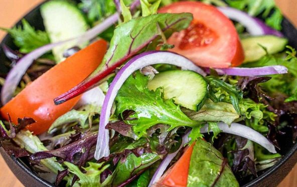 Side salad with mixed lettuce, tomato, cucumber and red onion