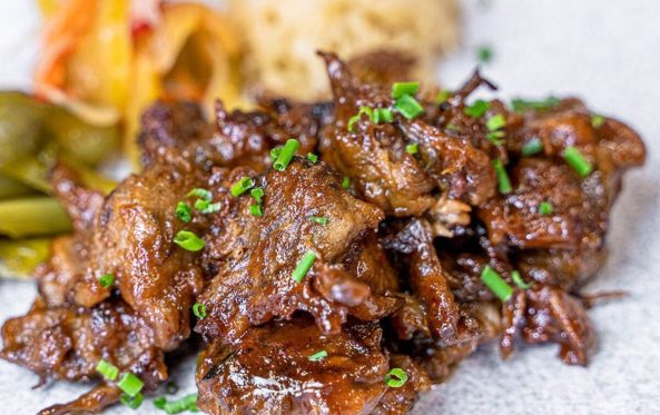 Chopped brisket burnt ends in sauce with spring onion