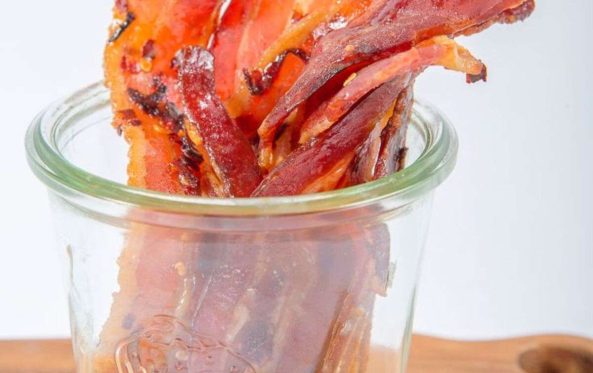 Candied bacon strips standing in a glass jar