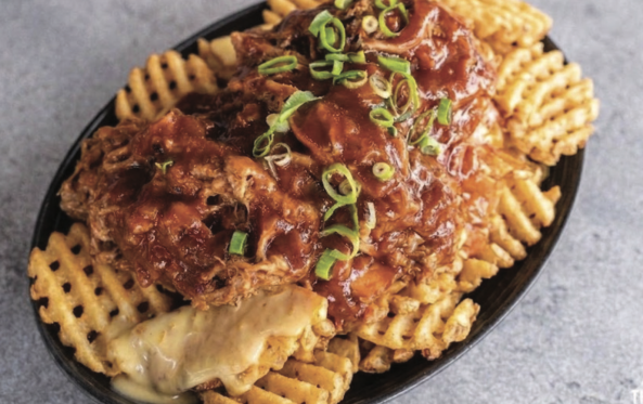 Waffle fries topped with pulled pork and spring onion
