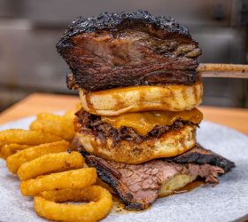 Beefy Mega Stack burger with onion rings on a plate