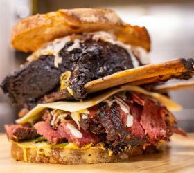 Reuben on Steroids sandwich stacked with sliced beef and melted cheese