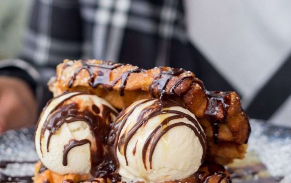 Waffle topped with vanilla ice cream and chocolate sauce